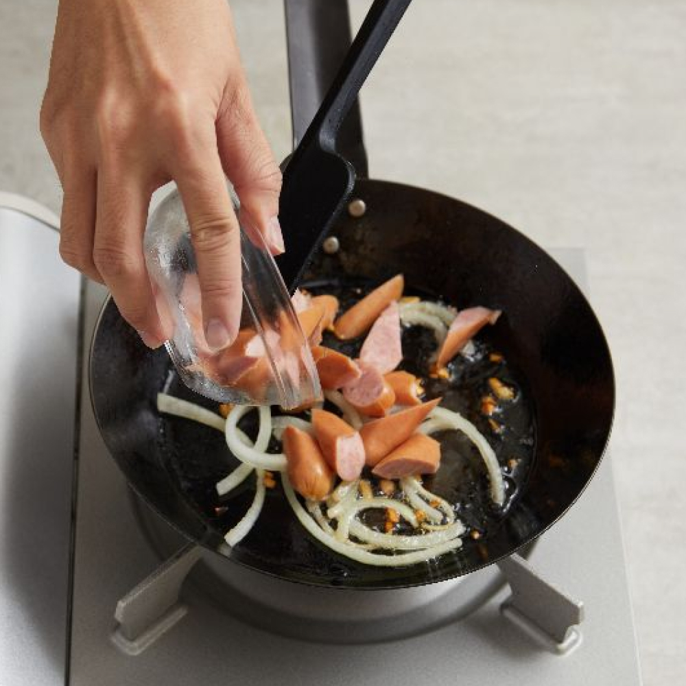 3.在預熱後的平底鍋中倒入橄欖油，再加入切碎的大蒜爆香，拌炒後待大蒜變為淺棕色後加入洋蔥、香腸，炒至洋蔥軟化。