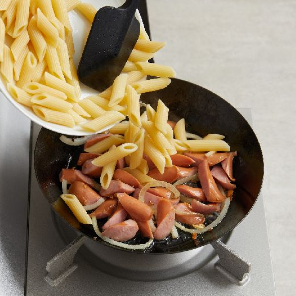 4.趁熱再加入筆尖麵、義大利麵醬，炒完上色後使用焗烤用盤盛裝。